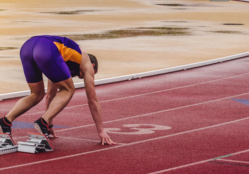 Corredor en los tacos de salida de una pista de atletismo